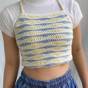 May include: A blue and cream striped crochet crop top with thin straps.