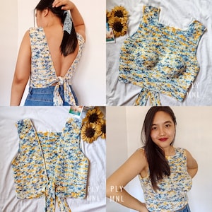 May include: A crocheted top with a tie back in a blue, yellow and white colour pattern. The top is shown on a model and laid flat.