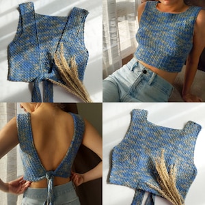 May include: A blue and beige crochet crop top with a tie back. The top is shown on a model wearing blue jeans.