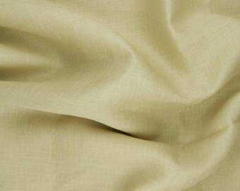 May include: A close-up of a light green fabric with a smooth, textured surface. The fabric is folded and draped, creating soft folds and wrinkles.
