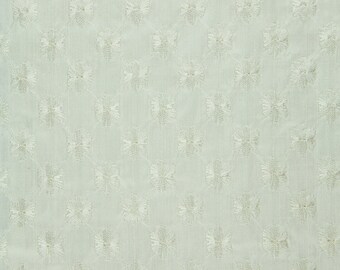 May include: White cotton fabric with a delicate, embossed pattern of small white flowers. The fabric has a subtle sheen and a soft, smooth texture.