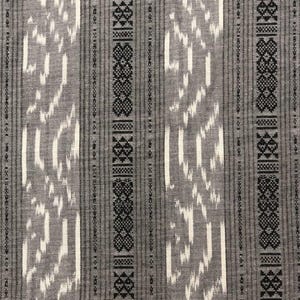 May include: Gray and white fabric with a black geometric pattern. The fabric has a woven texture and a subtle sheen.