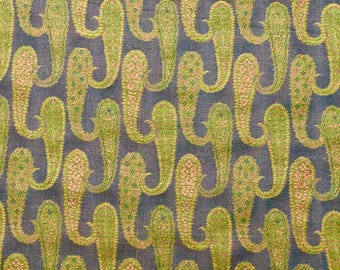 May include: A fabric with a repeating pattern of paisley shapes in shades of green, brown, and pink on a dark gray background.