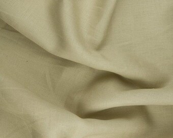 May include: A close-up of a light beige fabric with a subtle texture. The fabric is wrinkled and folded, showing its drape and softness.