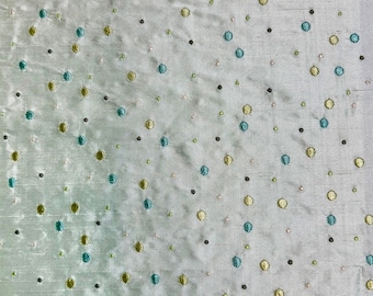May include: A light green fabric with a repeating pattern of small, embroidered circles in shades of green, blue, and brown.