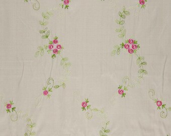 May include: White fabric with a repeating pattern of pink roses and green leaves embroidered on it.