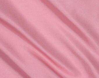 May include: A smooth, pale pink fabric with a subtle sheen. The fabric is draped and folded, creating soft curves and folds.