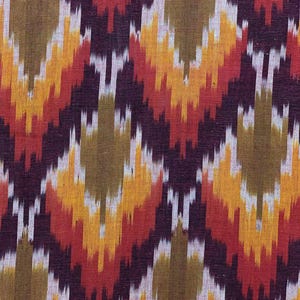 May include: Red, orange, yellow, brown, and white ikat fabric with a repeating pattern. The fabric is woven with a textured surface.