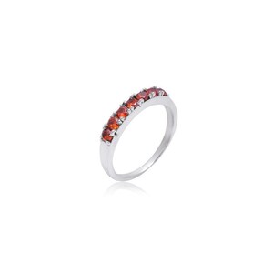 May include: A silver band ring with a row of small, red gemstones.