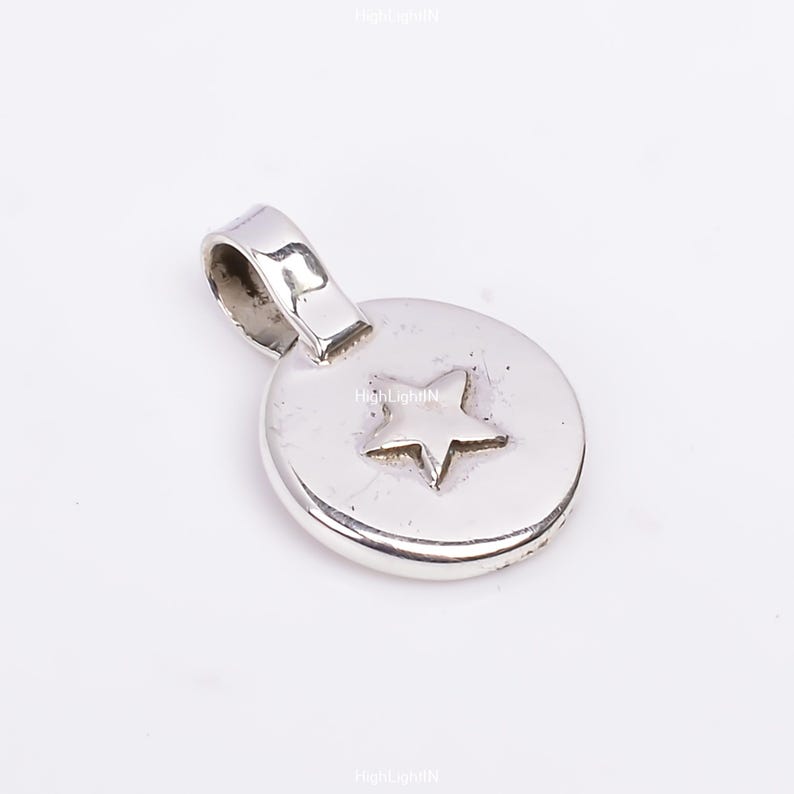 May include: Silver charm with a star design. The charm is round and has a loop for attaching to a bracelet or necklace.