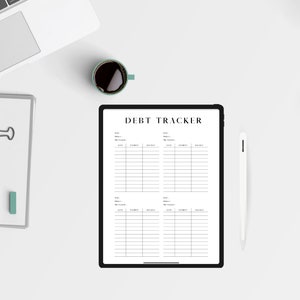 May include: A white tablet with a black border displaying a debt tracker spreadsheet. The tablet is on a white surface with a cup of coffee, a notebook, a pen, and a teapot.