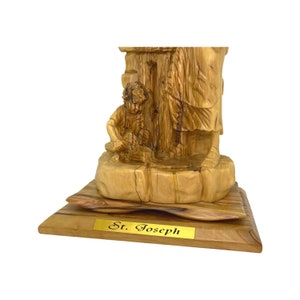 May include: Hand-carved wooden statue of Saint Joseph with a child, standing on a wooden base with a gold plaque that reads "St. Joseph".
