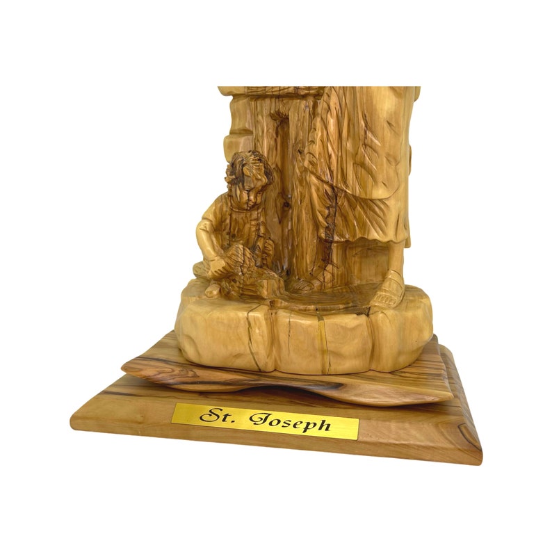 May include: Hand-carved wooden statue of Saint Joseph with a child, standing on a wooden base with a gold plaque that reads "St. Joseph".