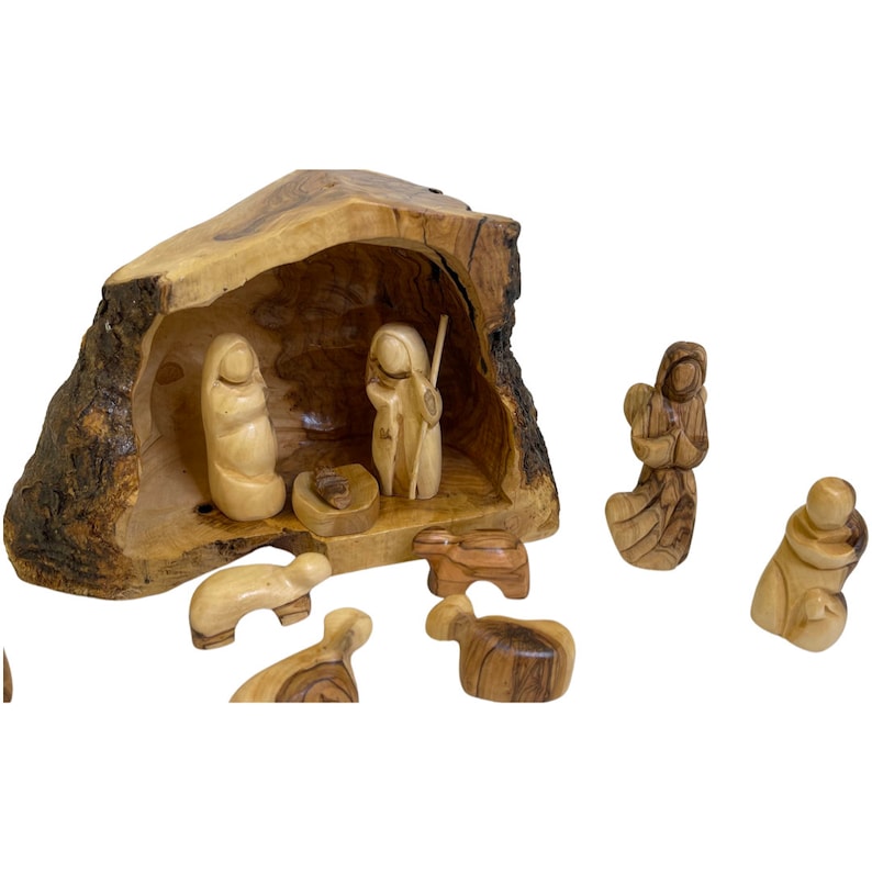 May include: A hand-carved olive wood nativity scene set with a manger, Mary, Joseph, a shepherd, an angel, and four sheep. The manger is a hollowed-out piece of olive wood.