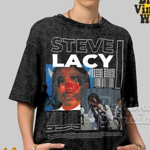 Può includere: Una t-shirt nera vintage lavata con una stampa grafica bianca del viso di Steve Lacy e il testo "STEVE LACY" e "GEMINI RIGHTS".