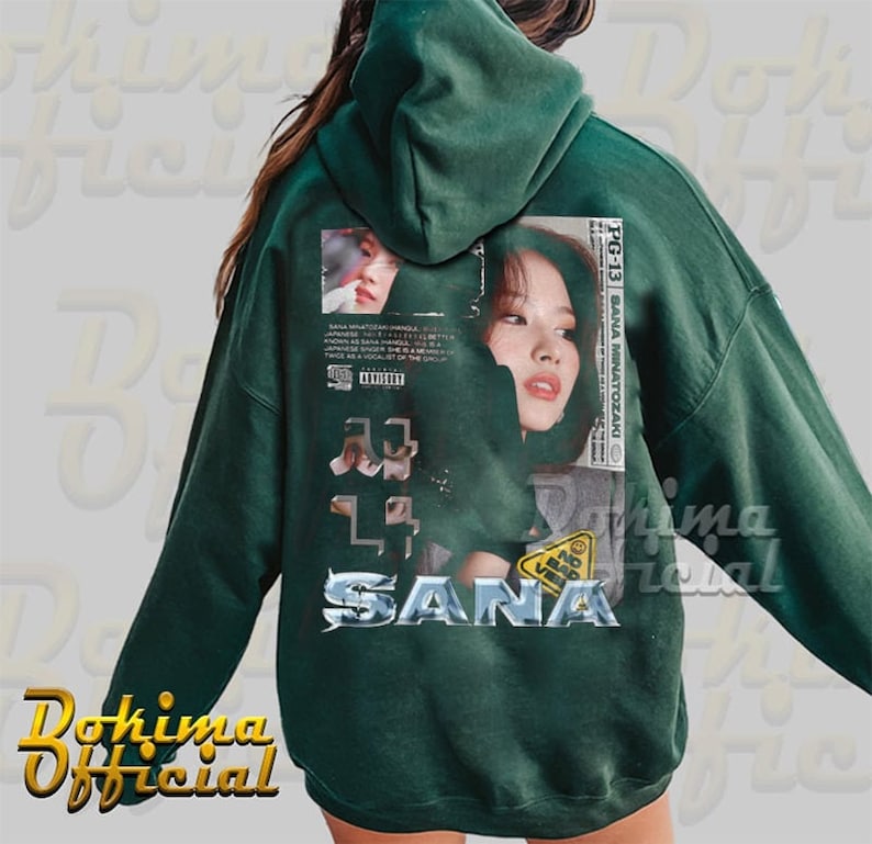 K&ouml;nnte beinhalten: Gr&uuml;ner Kapuzenpullover mit einem Grafikdruck eines Frauen Gesichts und dem Text "SANA" in einer silbernen Metallic-Schrift. Die Grafik enth&auml;lt auch den Text "PG-13" und "SANA MINATOZAKI".