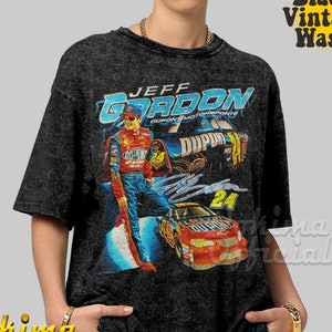 May include: A black t-shirt with a vintage-style graphic of NASCAR driver Jeff Gordon. The graphic features Gordon's name, the DuPont logo, and his race car number 24.