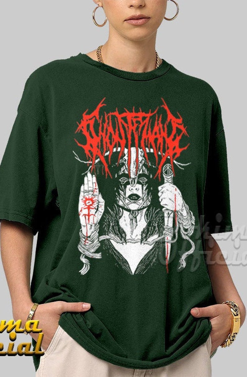 May include: A dark green t-shirt with a white and red graphic print of a woman with a skull mask and a knife. The text "GHOSTFACE" is printed in red above the woman.