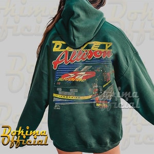 May include: Green hooded sweatshirt with a vintage-style graphic print of a race car with the text "Davey Allison" and "Thunderbird" on it.