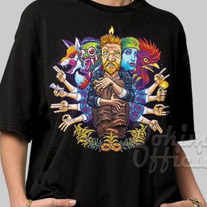 May include: Black t-shirt with a colorful graphic print of a man with multiple animal heads and arms. The graphic features a fox, a monster, a woman, and a rooster.