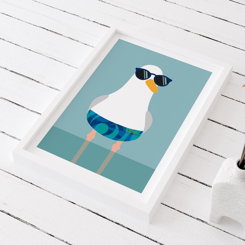 May include: Framed art print of a cartoon seagull wearing sunglasses and swim shorts. The seagull has a white body, grey wings, and an orange beak. The background is a light blue colour.