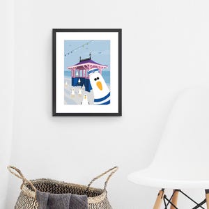 May include: A colorful illustration of a seagull wearing a sailor hat and standing in front of a pink and blue beach hut. The seagull is looking directly at the viewer. There are other seagulls in the background.