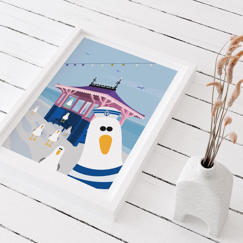 May include: A white seagull wearing a blue and white sailor hat stands in front of a pink and blue beach hut with a blue roof. The seagull has a yellow beak and black eyes. There are other seagulls in the background.