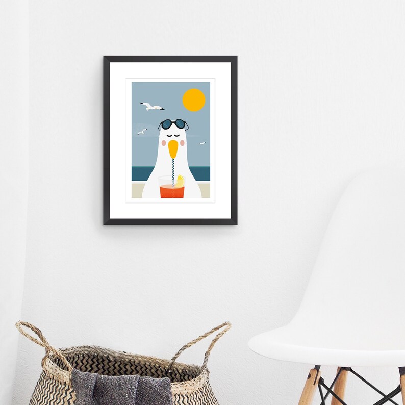 May include: A framed illustration of a cartoon seagull wearing sunglasses and drinking a glass of orange juice with a straw. The seagull is sitting on a beach with a yellow sun in the sky and seagulls flying overhead.