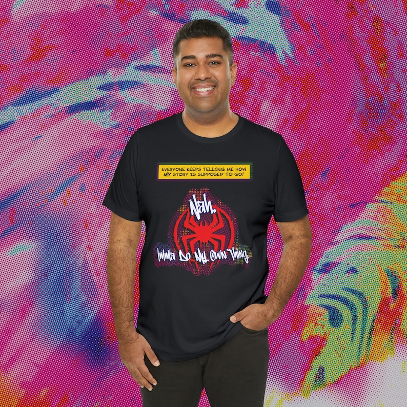 Puede incluir: Camiseta negra con un dise&ntilde;o de estilo c&oacute;mic. La camiseta presenta un gr&aacute;fico de ara&ntilde;a roja con la palabra "Nah" y la frase "Imma Do My Own Thing". Encima del gr&aacute;fico hay una pancarta amarilla con el texto "EVERYONE KEEPS TELLING ME HOW MY STORY IS SUPPOSED TO GO!"