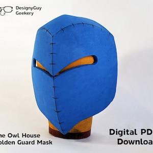 May include: A blue Golden Guard mask from The Owl House, with a geometric design and eye openings. The mask is made of a foam-like material and has black stitching details. The text "Digital PDF Download" is also visible.