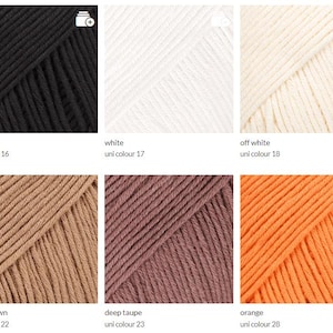 May include: A selection of yarn skeins in various colors, including black, white, off-white, light brown, deep taupe, and orange. Each skein is labeled with its color name and a unique identifier. The yarn appears to be a soft, textured material.