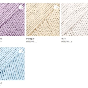 May include: Close-up of four skeins of yarn in various colors: sweet orchid, marzipan, chalk, and powder blue. The yarn is labeled with its color name and uni color number. The powder blue skein has a "NEW" label.