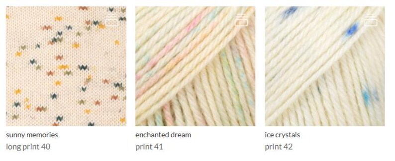 May include: Three skeins of yarn displayed side-by-side. The first is cream with multicolored specks labeled sunny memories long print 40. The second is cream with pastel stripes labeled enchanted dream print 41. The third is cream with blue specks labeled ice crystals print 42.
