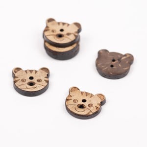 May include: Four wooden buttons with animal faces. Two buttons feature a tiger face with brown stripes and a brown background. Two buttons feature a bear face with a brown background.