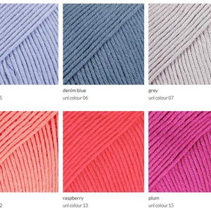May include: Close-up of six skeins of yarn in various colors. Colors include lavender, denim blue, grey, peach, raspberry, and plum. Each skein is labeled with its color name and a unique identifier.