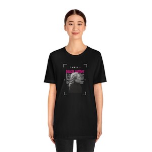 Peut inclure: T-shirt noir avec un imprim&eacute; graphique d'un visage de femme et le texte "I am a... black writer" en rose.
