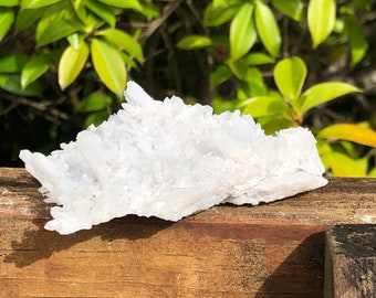 Può includere: Un ammasso di cristalli di quarzo bianco, con una texture ruvida e naturale. I cristalli sono disposti in una forma sciolta e organica, e hanno un aspetto leggermente traslucido.