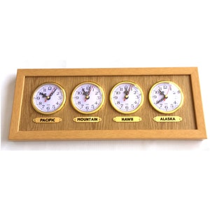 Puede incluir: Un reloj de pared de madera con cuatro zonas horarias: Pacífico, Montaña, Hawái y Alaska. Cada zona horaria tiene una esfera de reloj separada con manecillas negras y marcas de números romanos.