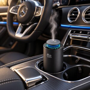 May include: A matte black cylindrical car aroma diffuser with the text Hello AROMAS printed in white. The device sits in a vehicle cup holder, features a glowing blue light ring, and emits a visible stream of mist from its top center vent.