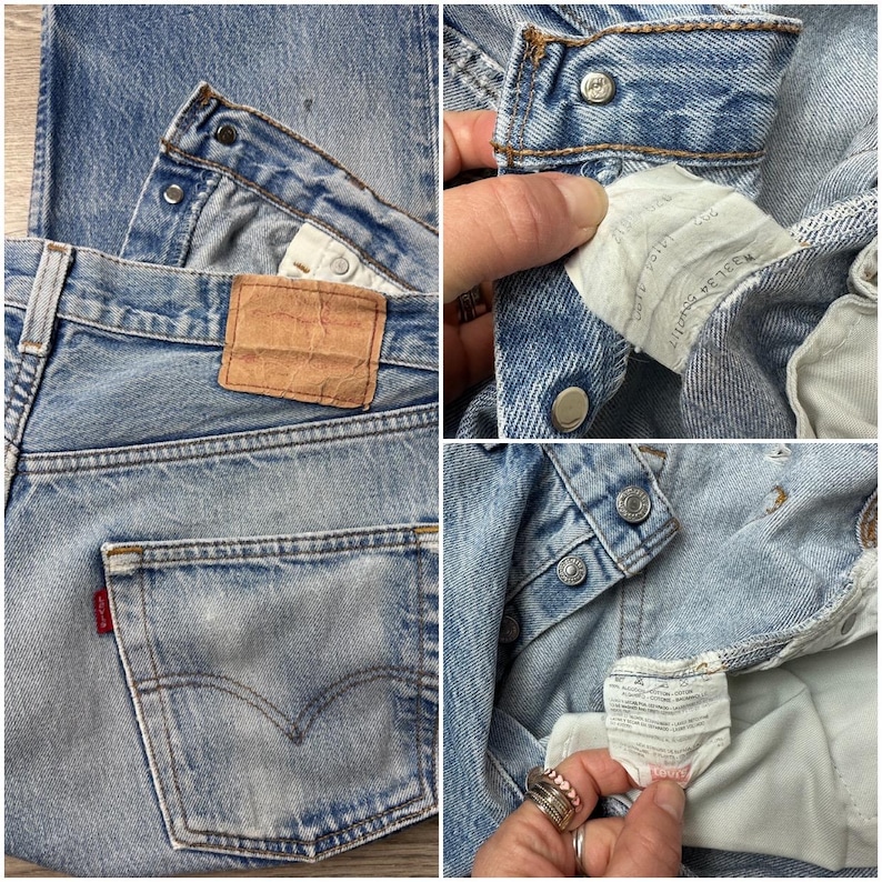 May include: Light blue denim jeans with a classic five-pocket design. Features a brown leather patch, a red tag on the back pocket, and metal button closures. The jeans show signs of wear and fading, giving them a vintage look.