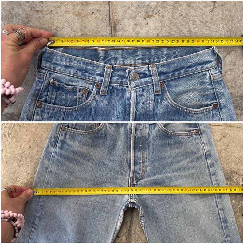 May include: Light blue denim jeans with a button fly and classic five-pocket design. A yellow measuring tape shows the waist measurement. The jeans are approximately 38 inches across the waist.