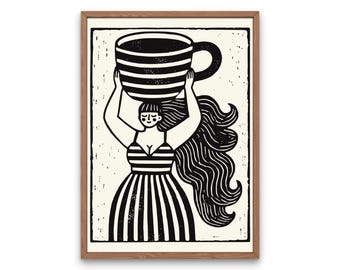May include: A framed black and white print featuring a stylized figure with long flowing hair wearing a striped dress. The figure holds a large, horizontally striped coffee cup above their head with both hands. The artwork has a textured, block-print aesthetic with a cream-colored background and a simple wooden frame.