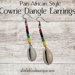 May include: Pan-African Style Cowrie Dangle Earrings with red, black, green, and yellow beads.
