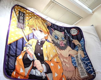 May include: A plush blanket featuring anime characters. The blanket has a purple border and showcases two characters with detailed illustrations. One character has yellow hair and an orange and yellow outfit, while the other has a boar's head and blue eyes.