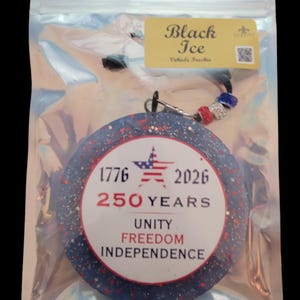May include: A round, blue and red air freshener with the text "1776 2026 250 YEARS UNITY FREEDOM INDEPENDENCE" in a clear plastic bag. The air freshener has a star and stripes design. The tag reads "Black Ice Vehicle Freshie."