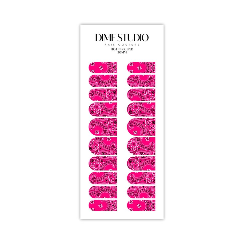 May include: A sheet of pink and black paisley nail stickers. The stickers are designed to look like a bandana. The sheet is labeled "Dime Studio Nail Couture Hot Pink Band 30mm".
