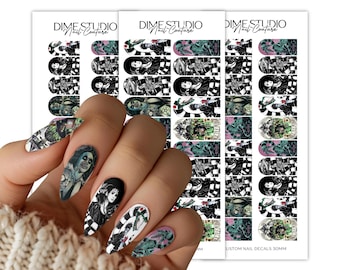 Pode incluir: Três folhas de decalques de unhas Dime Studio Nail Couture com várias ilustrações de personagens em preto, branco e verde. Os decalques incluem retratos e padrões de listras, alguns aplicados em unhas amendoadas. O texto diz Dime Studio.