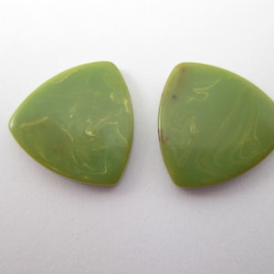 May include: Two olive green, triangular-shaped earrings. Each earring has a marbled, swirled pattern in a lighter shade of green. The earrings are displayed on a white background.