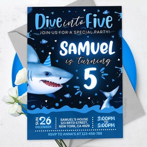 May include: A blue and white birthday party invitation with a shark illustration. The invitation says "Dive into Five" and "Samuel is turning 5". The date is December 26th and the time is 3:00 PM to 5:00 PM. The address is Samuel's House, 123 BRTD Street, New York, CA 4929. The RSVP information is to call Anna's at 123-456-789.