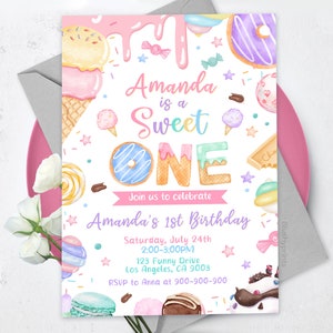 以下が含まれることがあります： ピンクと白の誕生日招待状で、水彩画で描かれたお菓子と「Amanda is a Sweet One」というテキストが書かれています。招待状には、アマンダの1歳の誕生日パーティーの詳細が記載されており、日付、時間、場所、RSVP情報などが含まれています。